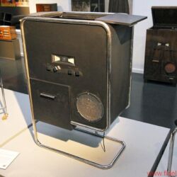 Bang & Olufsen BeoLab 90 - Szenen einer Geburtstagsfeier: CEO Tue Mantoni vor der Enthüllung der BeoLab 90, Gründer-Nachfahrin und Enkel beim Sektempfang im historischen Herrenhaus, Streifzug durchs B&O-Museum, Uralt-Mikrofon als Teil der Ausstellung